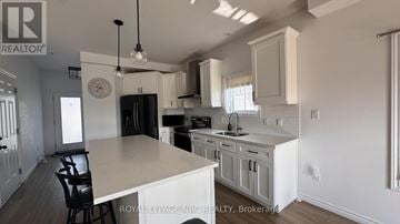 Fort Erie (Lakeshore) townhouse for rent - A kitchen with a table and chairs in the middle of it.