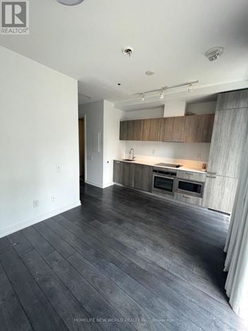 Toronto (Church-Yonge Corridor) condo for rent - A spacious kitchen with wooden cabinets and a large island.