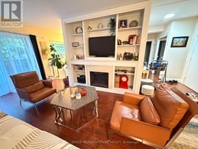 Hamilton (Corman) condo for rent - A living room with a brown leather chair and a grey coffee table.