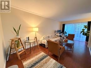 Hamilton (Corman) condo for rent - A well-lit bedroom with a bed, chair, and potted plant.