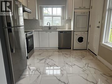 Vancouver apartment for rent - A kitchen with a marble floor and white cabinets.