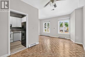 Toronto (Moss Park) multi-family for rent - A spacious room with a kitchen area and a ceiling fan.
