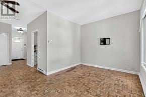 Toronto (Moss Park) multi-family for rent - A room with a wooden floor and a white door.