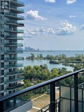 Toronto (Mimico) condo for rent - A view from a balcony overlooking a body of water with a city skyline in the distance.