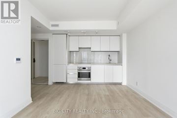 Toronto (Thorncliffe Park) condo for rent - A white kitchen with a refrigerator, oven, and cabinets.