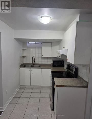 Brampton (Bram East) apartment for rent - A kitchen with white cabinets and a granite counter.