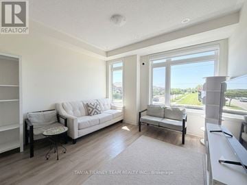 Whitby (Taunton North) townhouse for rent - A living room with a couch, chair, and a table with a glass top.