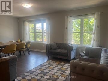 Oakville (Go Glenorchy) townhouse for rent - A living room with a dining table and chairs.