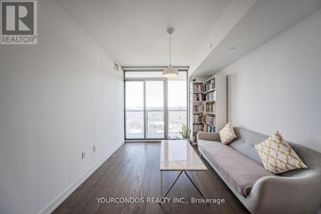Toronto (Bay Street Corridor) condo for rent - A living room with a grey couch and a bookshelf.
