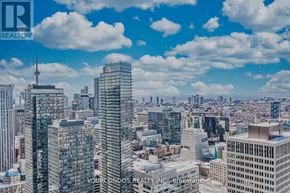 Toronto (Bay Street Corridor) condo for rent - A cityscape with skyscrapers and a blue sky with clouds.