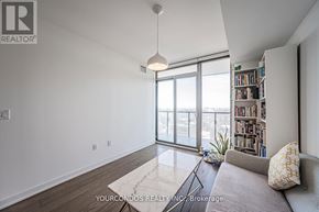 Toronto (Bay Street Corridor) condo for rent - A living room with a couch, a bookshelf, and a large window.