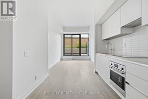 Toronto (Thorncliffe Park) condo for rent - A white kitchen with a window overlooking a field.