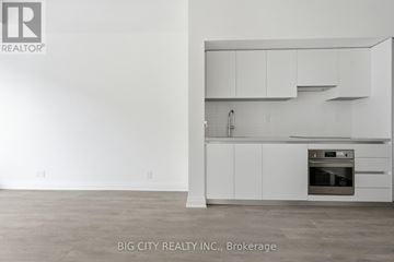 Toronto (Thorncliffe Park) condo for rent - A white kitchen with a stove top oven and cabinets.
