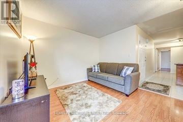Toronto (Clairlea-Birchmount) townhouse for rent - A living room with a grey couch and a wooden floor.