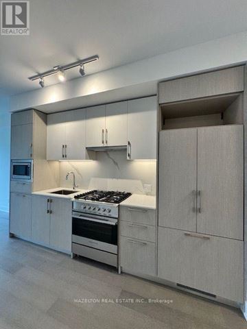 Toronto (Yonge-Eglinton) condo for rent - A modern kitchen with white cabinets and stainless steel appliances.