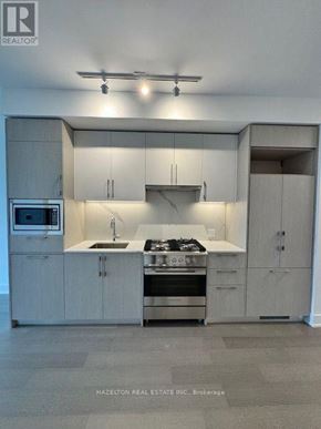 Toronto (Yonge-Eglinton) condo for rent - A modern kitchen with a stove top oven and microwave.