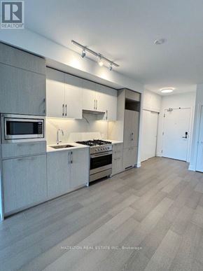 Toronto (Yonge-Eglinton) condo for rent - A modern kitchen with a microwave, oven, and sink.