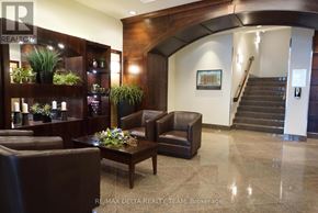 Ottawa condo for rent - A well-lit waiting area with a brown leather couch, a wooden coffee table, and a staircase in the background.