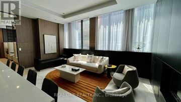 Toronto (Waterfront Communities) condo for rent - A modern living room with a large sofa and a coffee table.