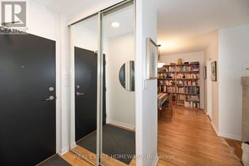 Toronto (Oakridge) condo for rent - A living room with grey couches and a television on the wall.