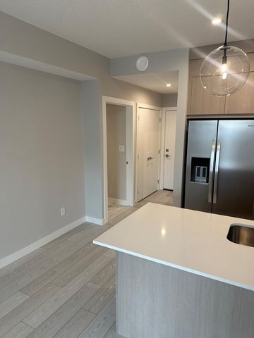 Calgary apartment for rent - A kitchen with a white counter and a stainless steel refrigerator.