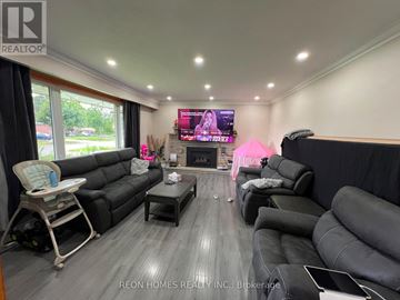 Oshawa (Donevan) apartment for rent - A living room with a grey sofa set and a television displaying a pink screen.