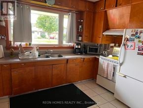 Oshawa (Donevan) apartment for rent - A kitchen with wooden cabinets and a white refrigerator.
