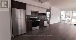 Burlington (Lasalle) condo for rent - A kitchen with a refrigerator and a stove top oven.