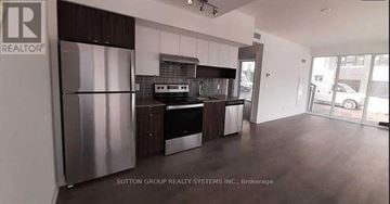 Burlington (Lasalle) condo for rent - A kitchen with a refrigerator and a stove top oven.