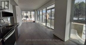 Burlington (Lasalle) condo for rent - A spacious room with large windows and a kitchen area.