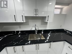 Toronto (Blake-Jones) apartment for rent - A modern kitchen with a marble countertop and white cabinets.