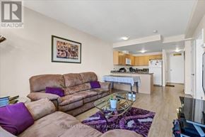 Hamilton (Corktown) condo for rent - A living room with a brown couch and a purple pillow.