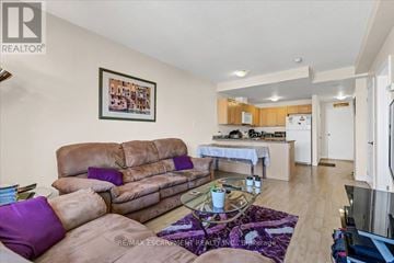 Hamilton (Corktown) condo for rent - A living room with a brown couch and a purple pillow.