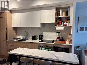 Toronto condo for rent - A kitchen with a marble table and white cabinets.