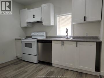 Chatham apartment for rent - A kitchen with white cabinets and a stove top oven.