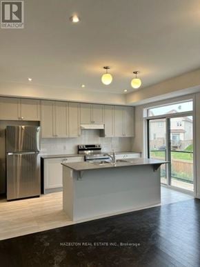 Whitby (Port Whitby) townhouse for rent - A modern kitchen with a refrigerator, stove, and sink.