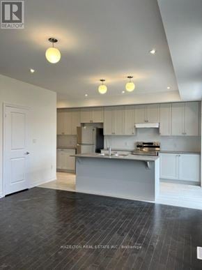 Whitby (Port Whitby) townhouse for rent - A modern kitchen with a large island and wooden flooring.