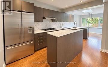 Toronto (Leaside) apartment for rent - A modern kitchen with stainless steel appliances and wooden flooring.