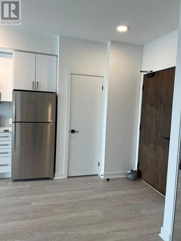 Hamilton (Riverdale) condo for rent - A modern kitchen with a stainless steel refrigerator and white cabinets.