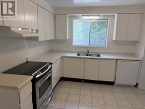 Welland (N. Welland) townhouse for rent - A kitchen with white cabinets and a black countertop.