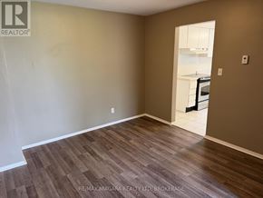 Welland (N. Welland) townhouse for rent - A room with brown wooden flooring and a white door leading to another room.