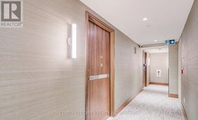 Toronto (Waterfront Communities) condo for rent - A hallway with a wooden door and a sign that says "EXIT".
