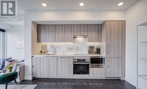Toronto (Waterfront Communities) condo for rent - A modern kitchen with wooden cabinets and a black oven.