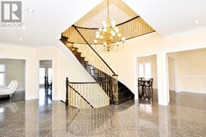 Mississauga (Central Erin Mills) apartment for rent - A large, open-plan living space with a staircase and a chandelier.