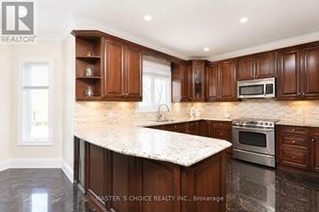 Mississauga (Central Erin Mills) apartment for rent - A kitchen with brown cabinets and a granite countertop.
