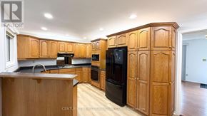 London North (North K) apartment for rent - A kitchen with wooden cabinets and a black refrigerator.