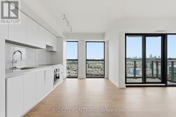Toronto (Thorncliffe Park) condo for rent - A spacious kitchen with white cabinets and a view of the city.