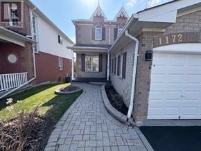 Oshawa (Pinecrest) apartment for rent - A brick house with a white garage door and a sign that says 1172.