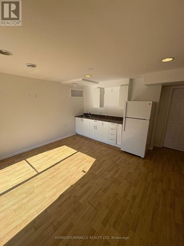 Oshawa (Pinecrest) apartment for rent - A kitchen with white cabinets and a wooden floor.
