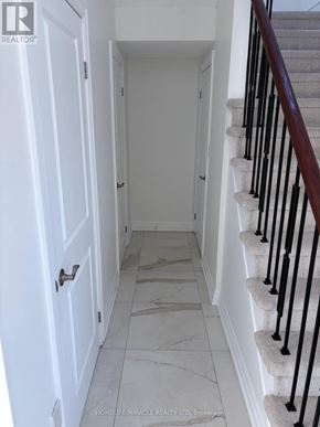 Oshawa (Pinecrest) apartment for rent - A hallway with a staircase and a white door.